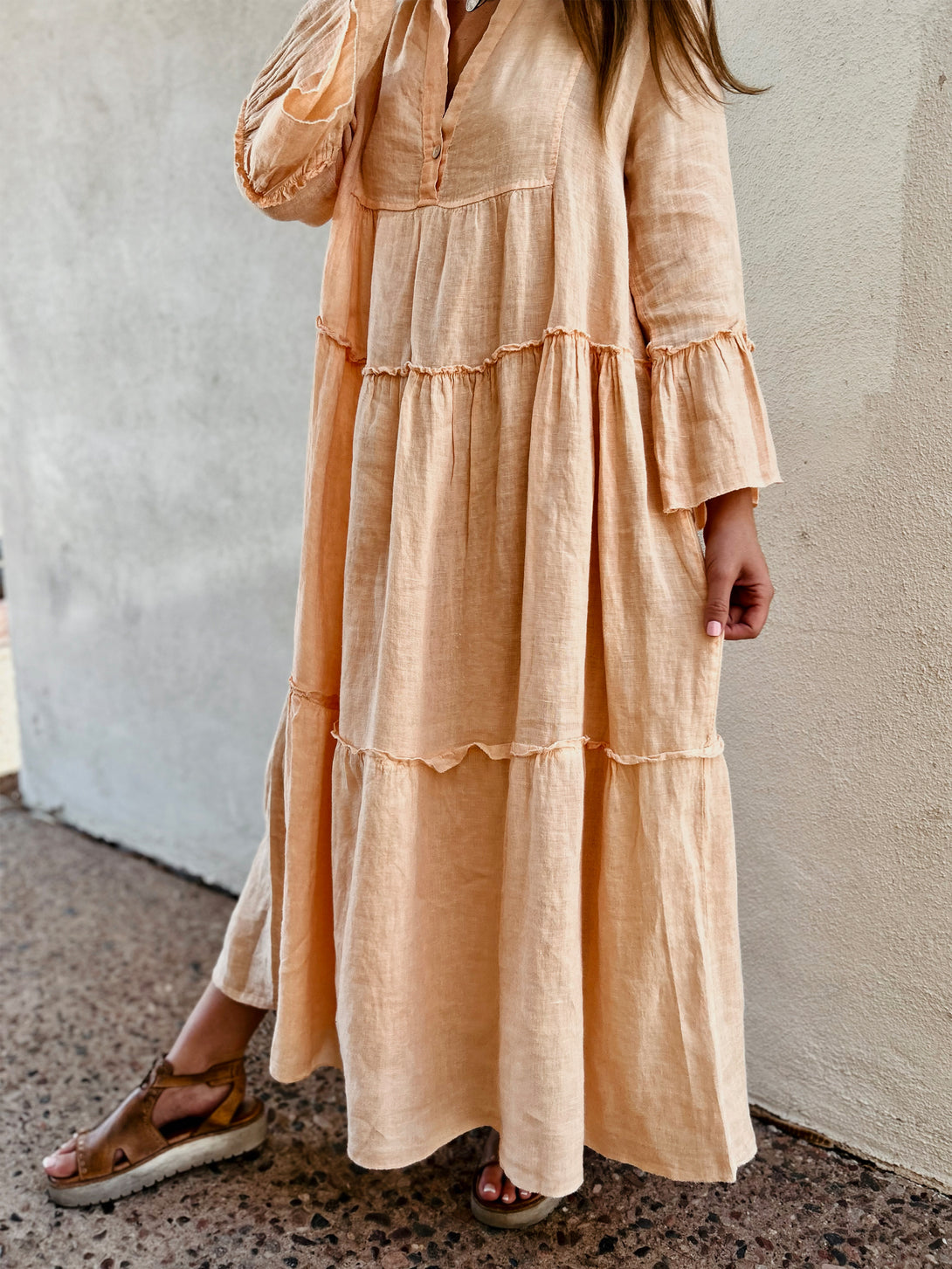 Conscious Coterie Adele Dress in Peach on model touching dress front view