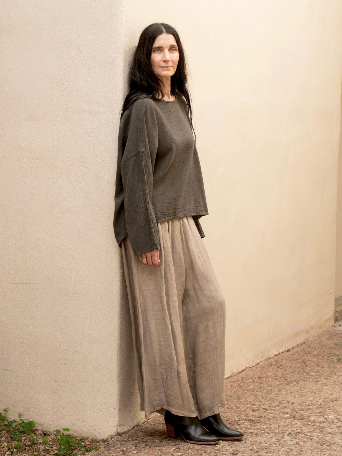 Conscious Coterie Alyssa top in charcoal grey full body view on woman leaning against the wall