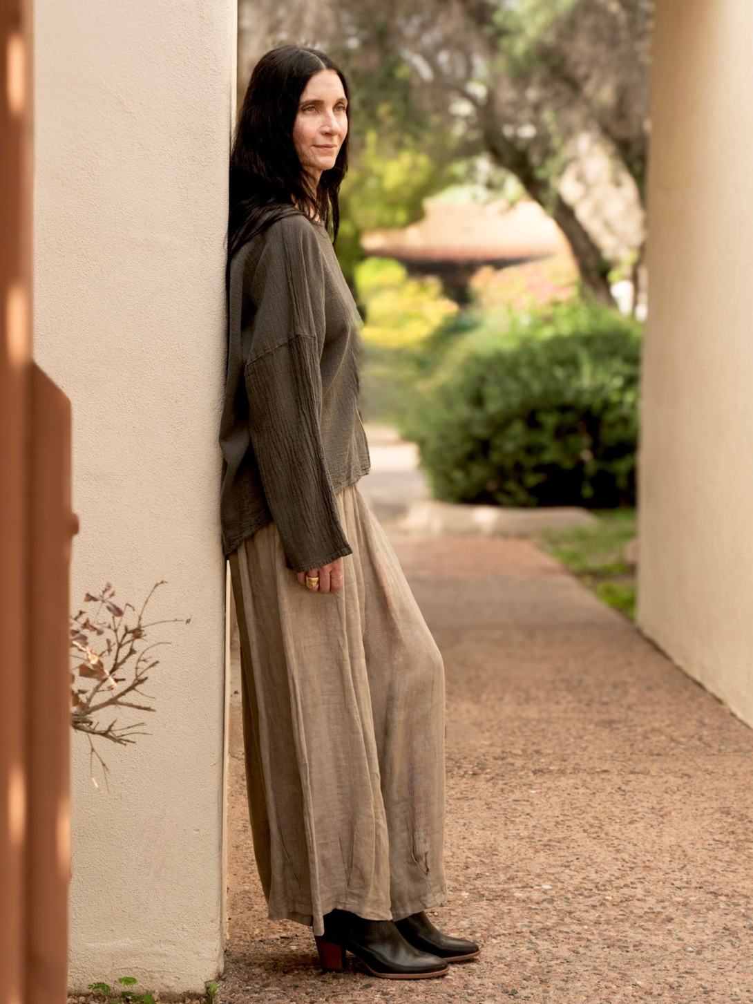 Conscious Coterie Alyssa top in charcoal grey woman showing side view of the top with her arm down to her side