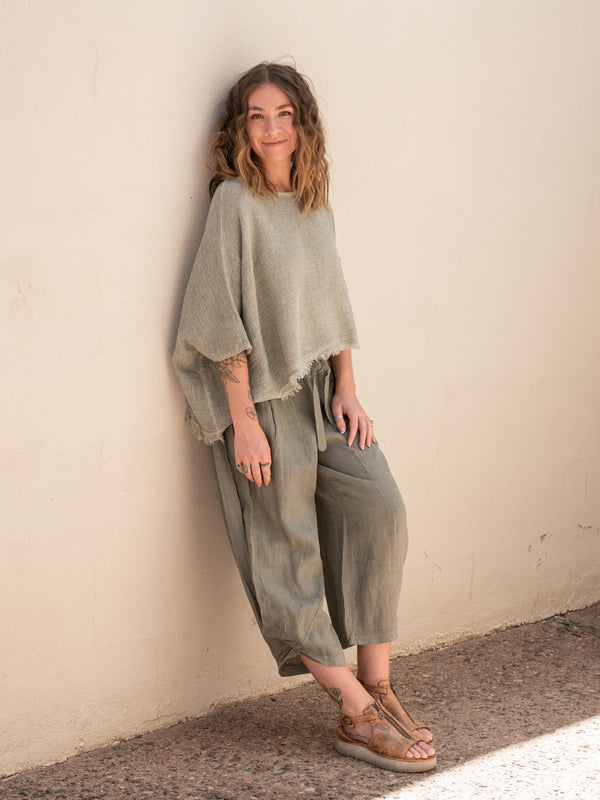 Conscious Coterie Bondi Linen Top in Olive on model smiling leaning against wall