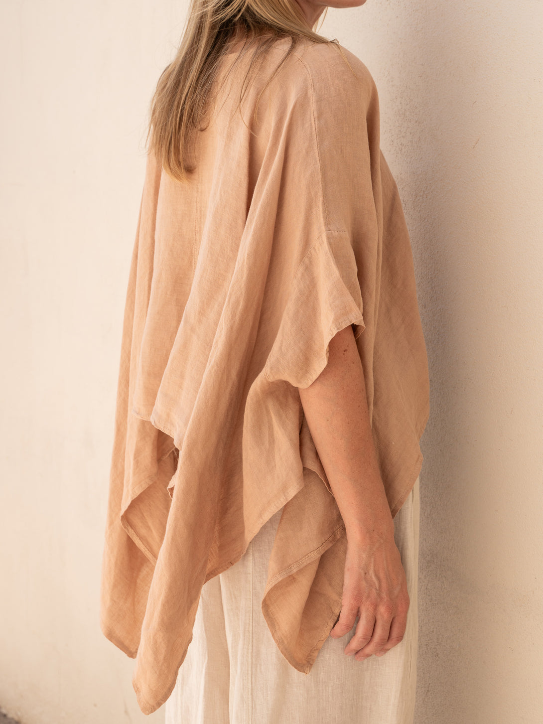 Conscious Coterie Brynn Linen Top in camel on model wearing beige pants back view