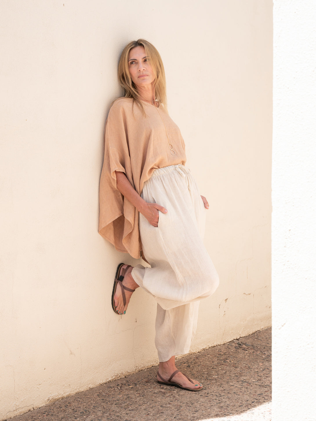 Conscious Coterie Brynn Linen Top in camel on model wearing beige pants full side view