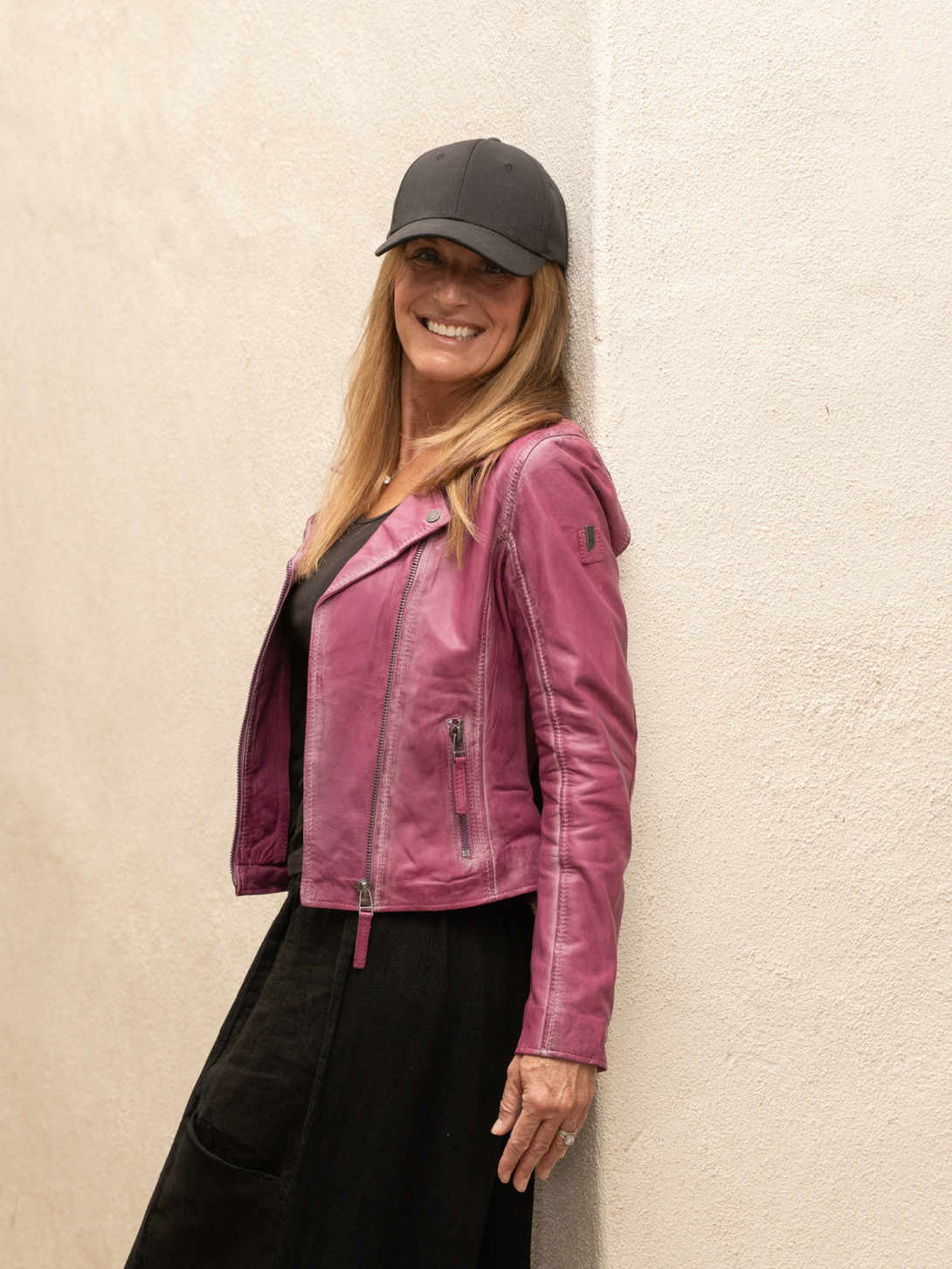 Conscious Coterie Christy star leather jacket in dark pink side view close up on model smiling and wearing jacket 