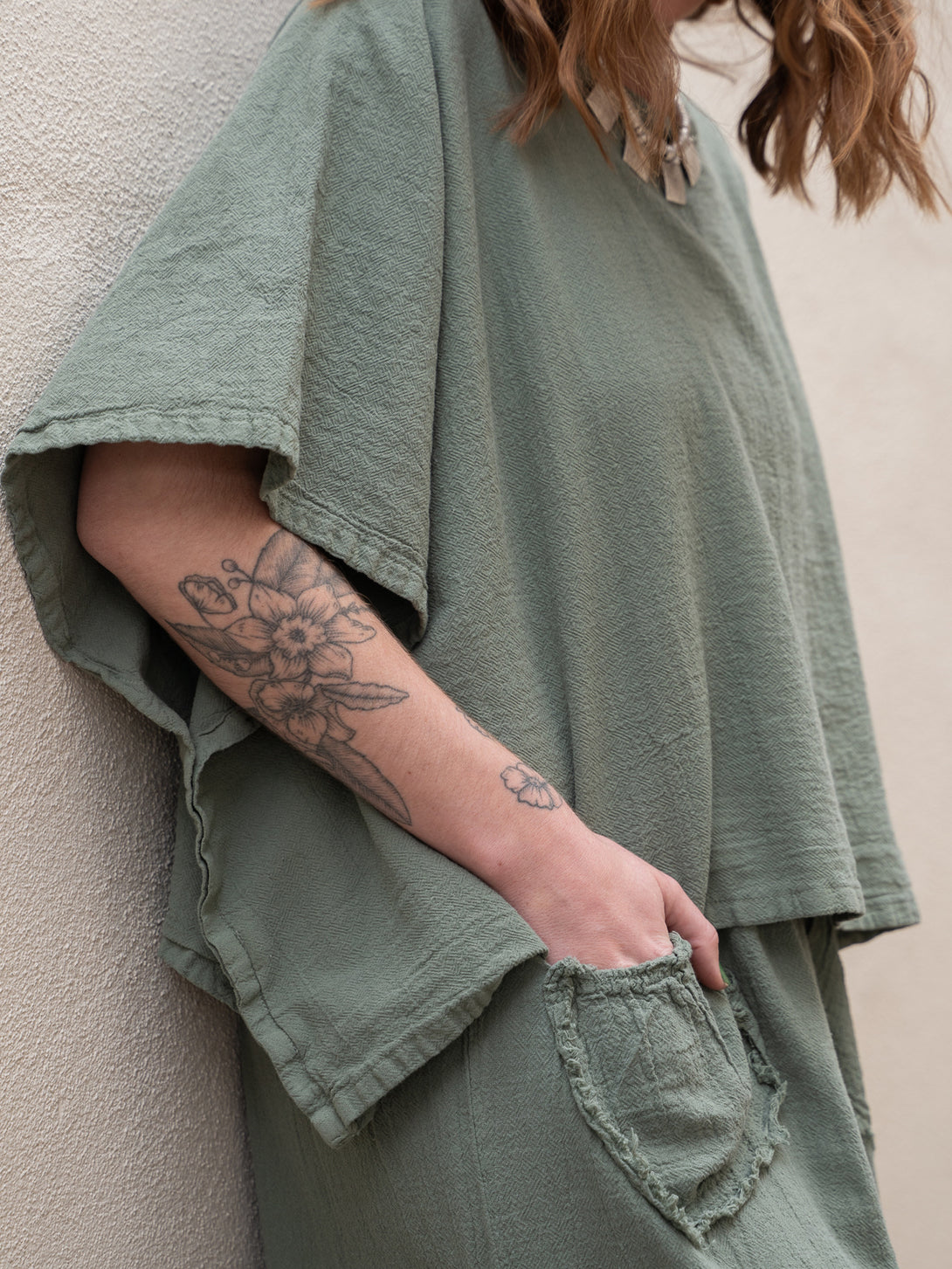Conscious Coterie Dolly Pant in sage cotton on model with hand in pocket side view