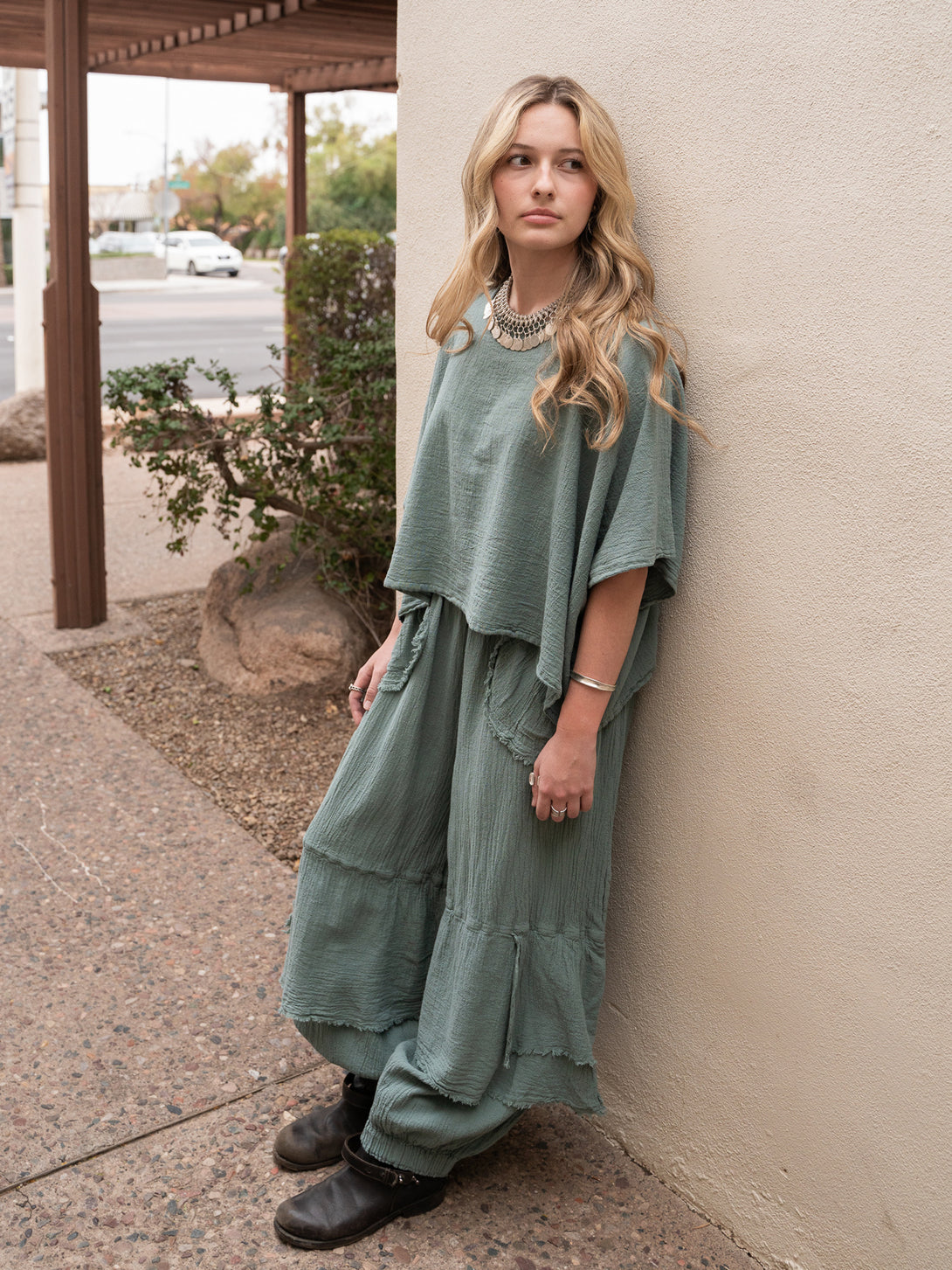 Conscious Coterie Dolly Pant in sea cotton on model leaning against wall full front side view