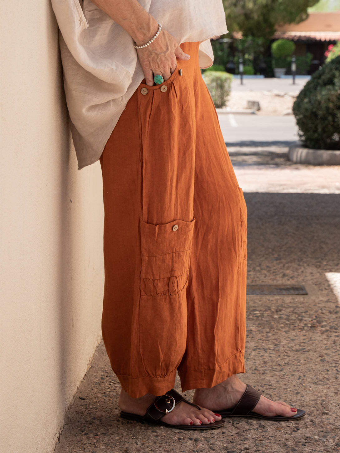 Conscious Coterie Holly Linen Pant in rust on model side view