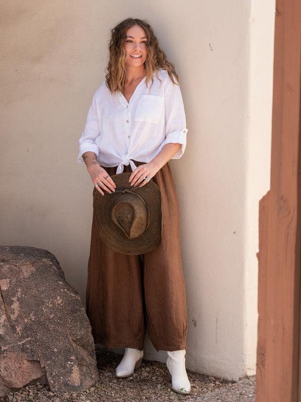 Conscious Coterie Jodi Linen Top in White on model holding cowboy hat full front view