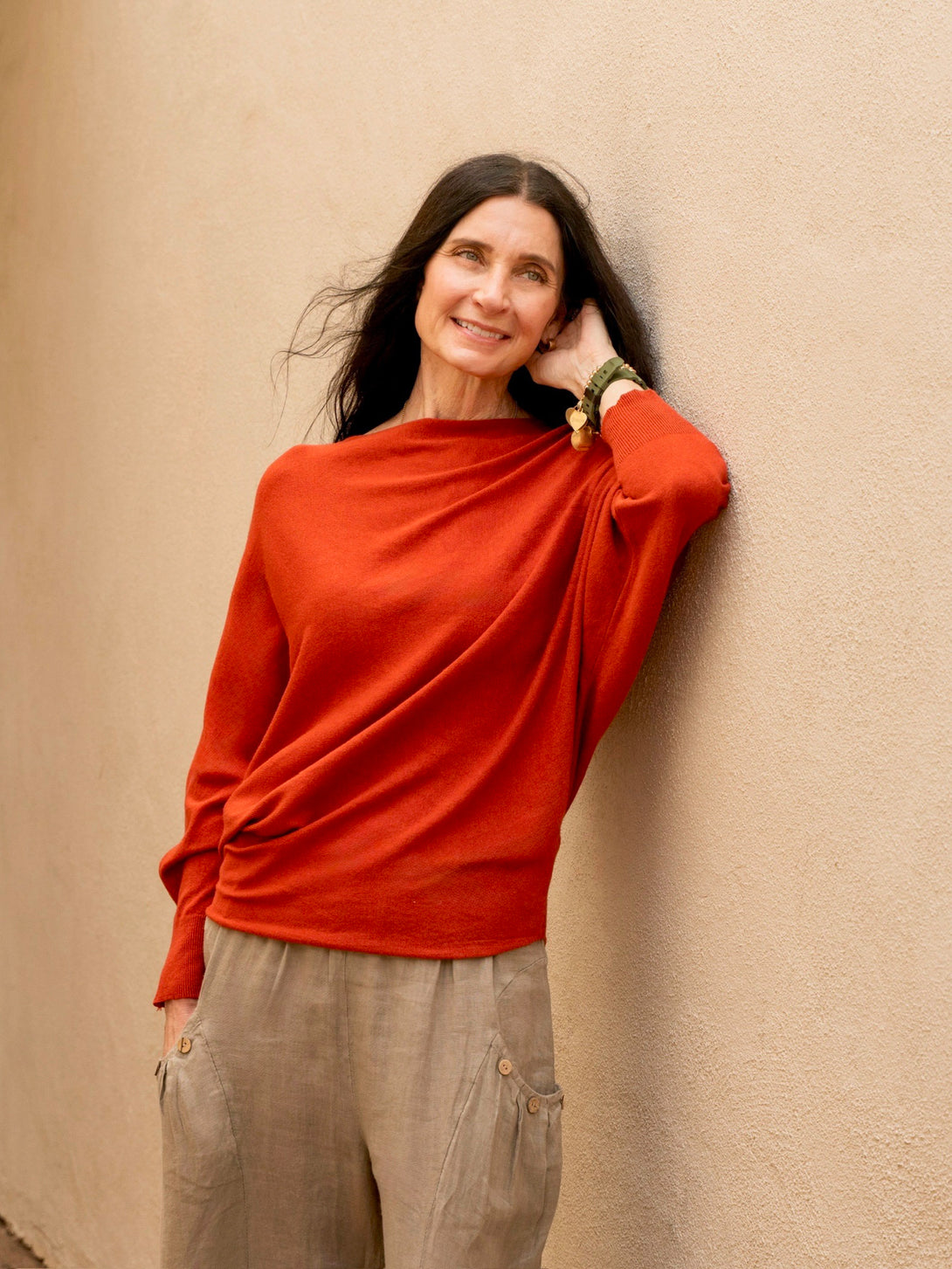 Conscious Coterie Kayla Long Sleeve Sweater in rust on model touching left ear front view