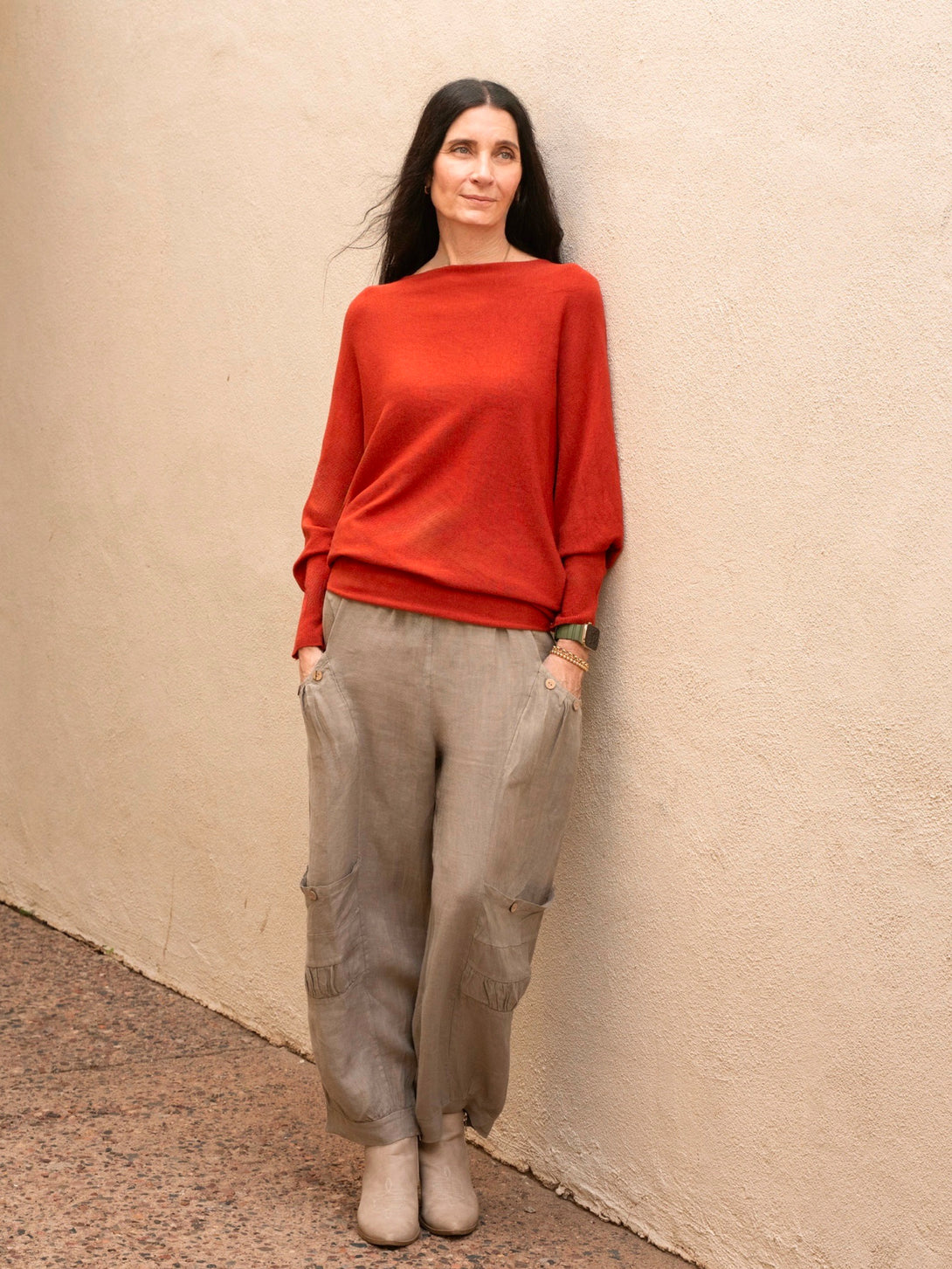 Conscious Coterie Kayla Long Sleeve Sweater in rust on model with hands in pockets full front view