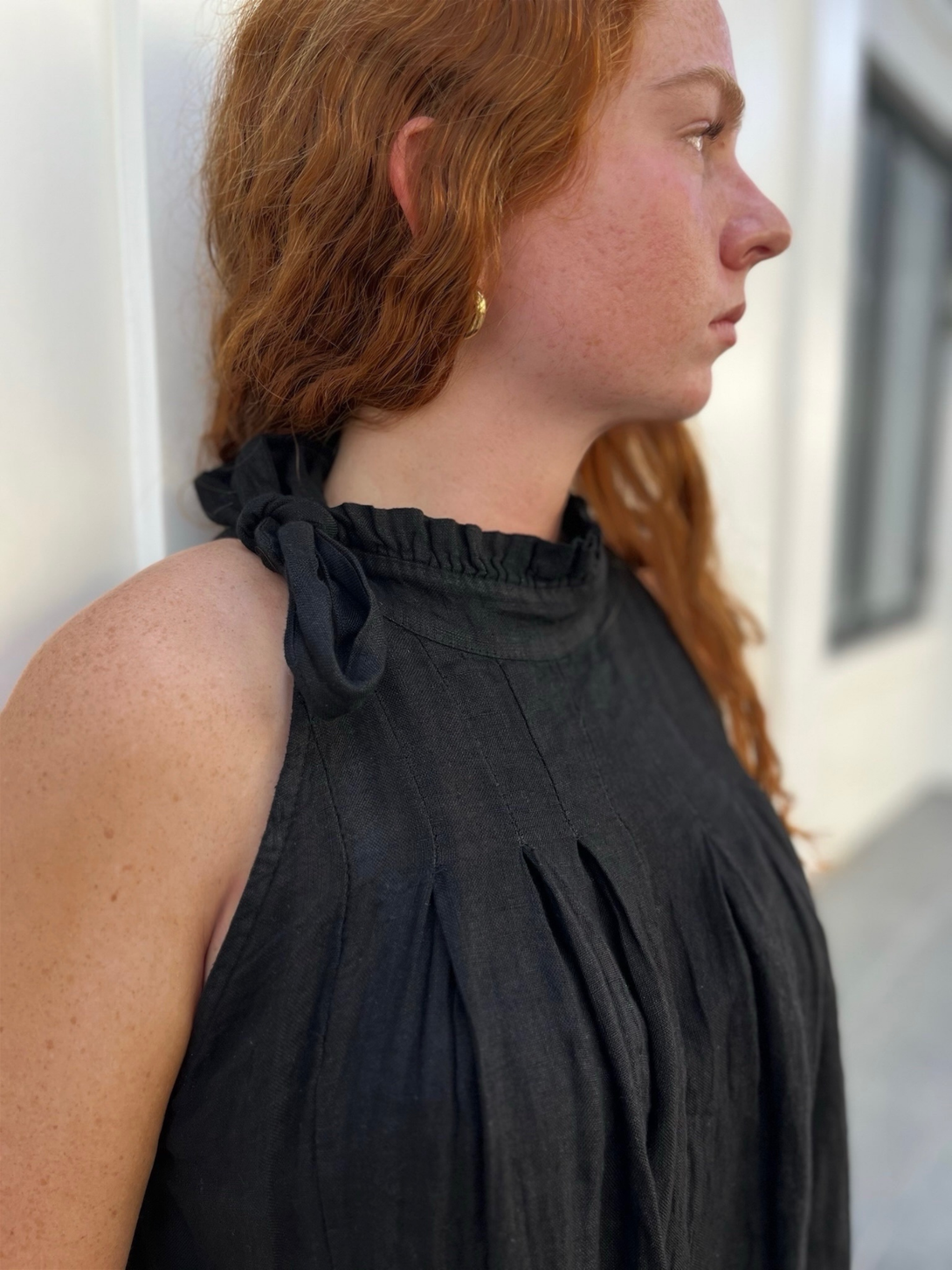 Conscious Coterie Kristen Jumpsuit in black close up view of bow tie and ruffle neckline on jumpsuit