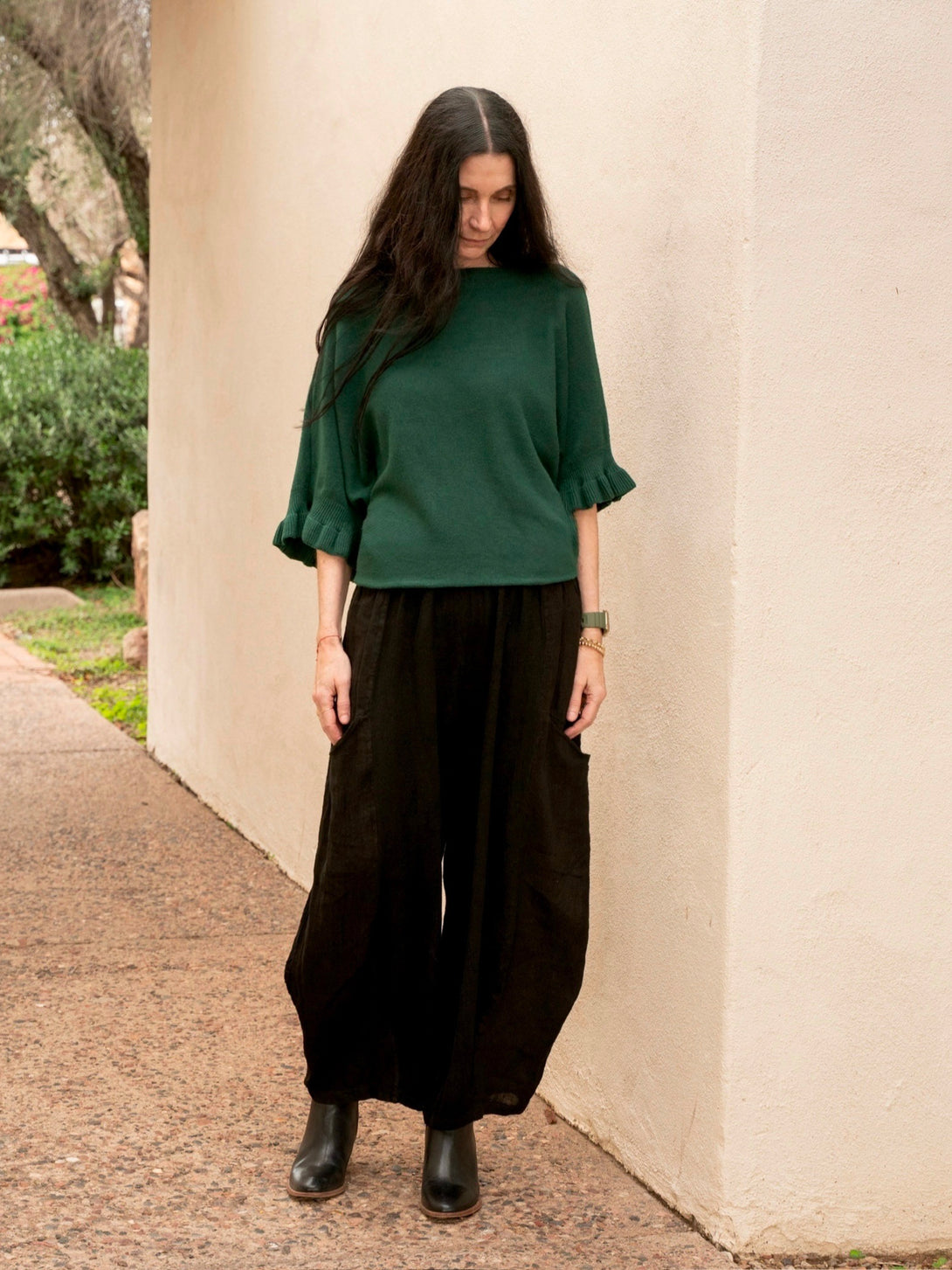 Conscious Coterie Lila Ruffle Sleeve Sweater in forest green on model looking down full front view