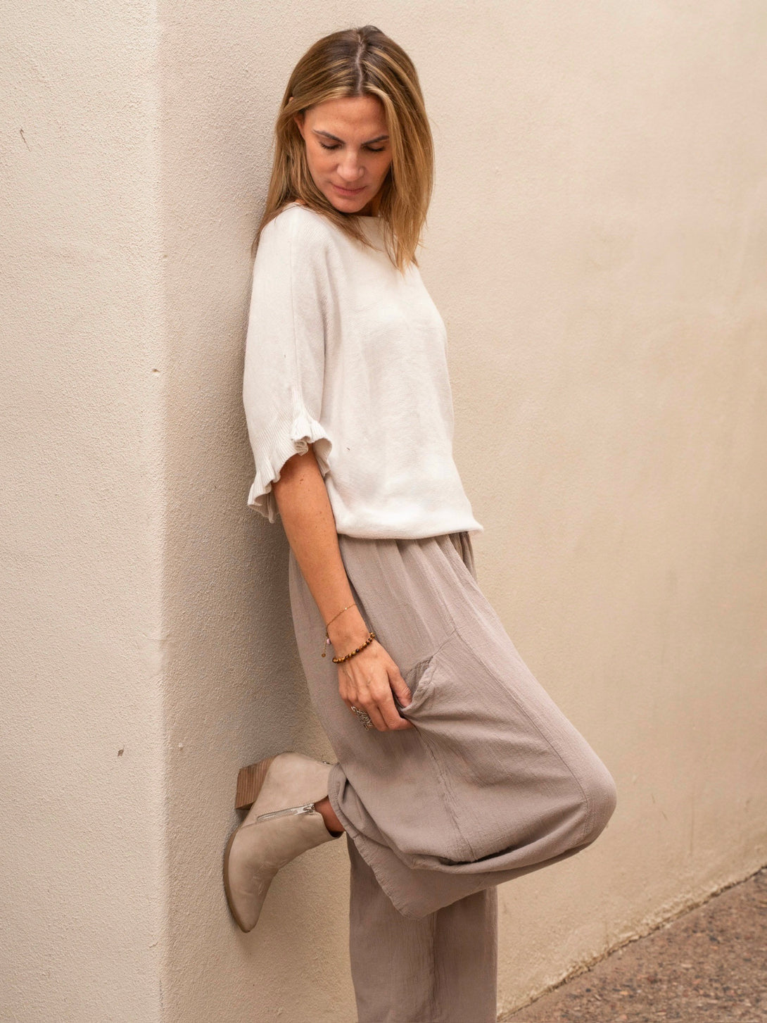 Conscious Coterie Lila Ruffle Sleeve Sweater in light beige on model looking down side view