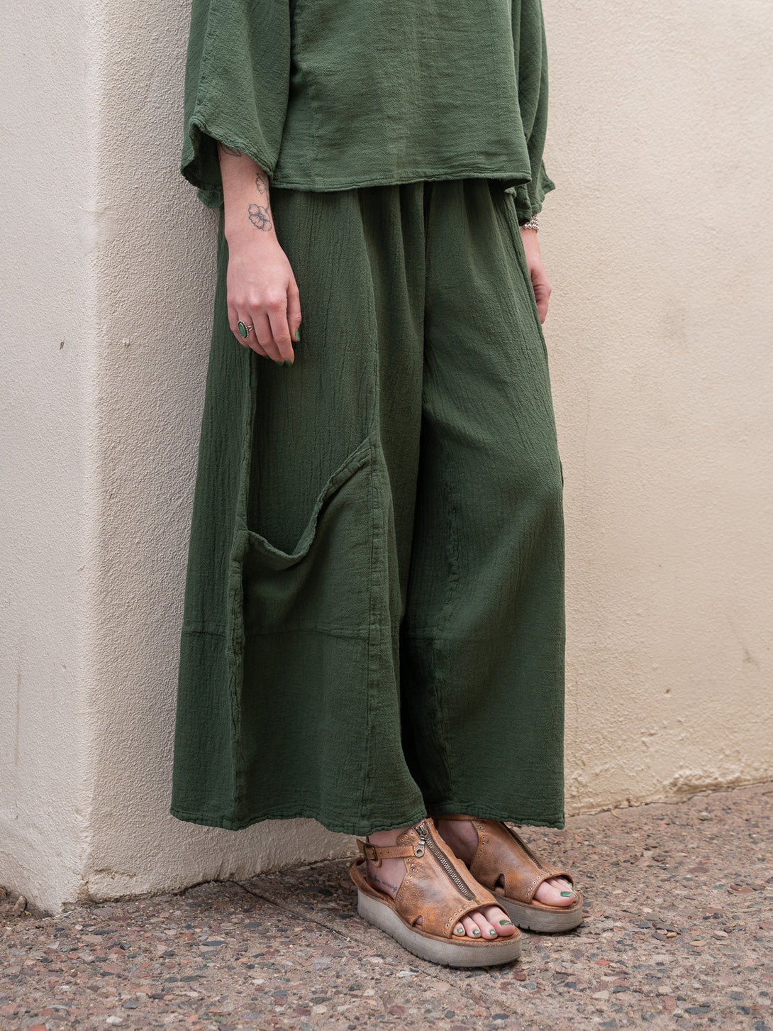 Conscious Coterie Lucy Pant in moss cotton on model front bottom view