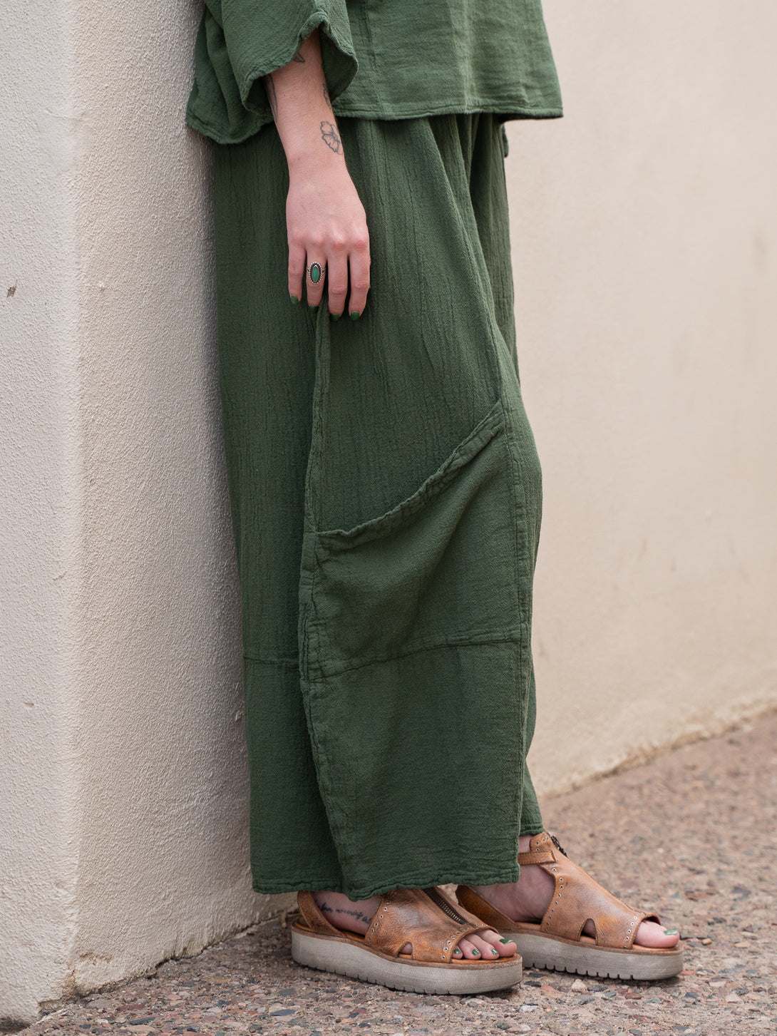 Conscious Coterie Lucy Pant in moss cotton on model side bottom view