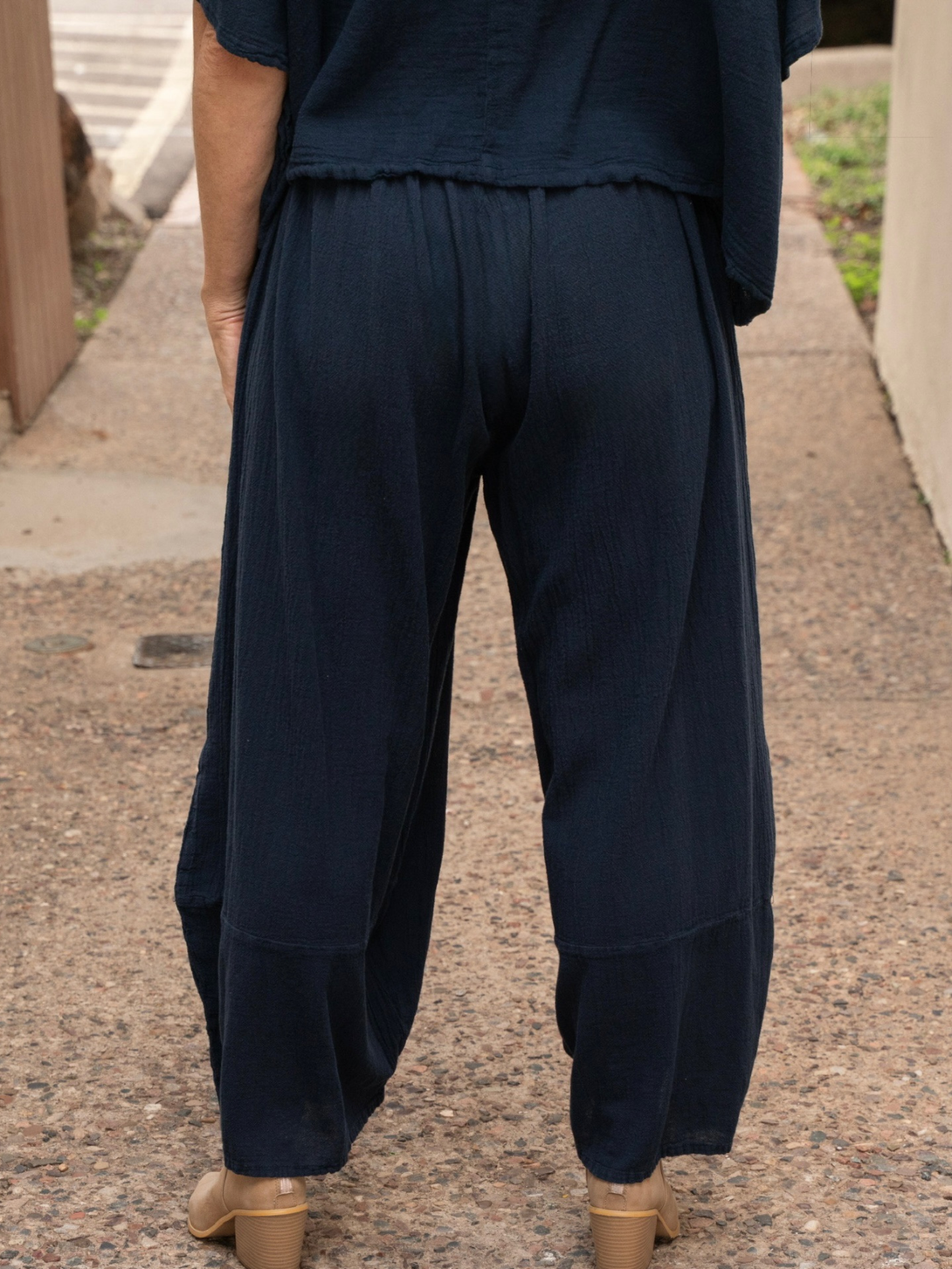 Conscious Coterie Lucy pant in navy blue model facing backwards showing the back view of the pants