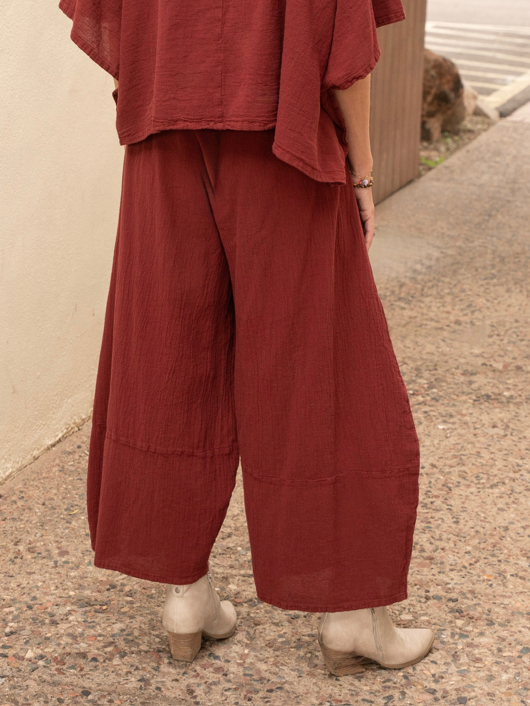 Conscious Coterie Lucy cotton pant in wine red woman in wide stance showing back view of the pants from behind