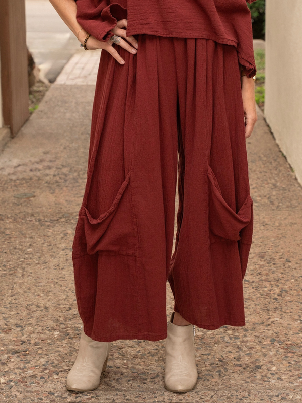 Conscious Coterie Lucy cotton pant in wine red close up photo of woman facing forward showing the front of the pants with a hand on her hip