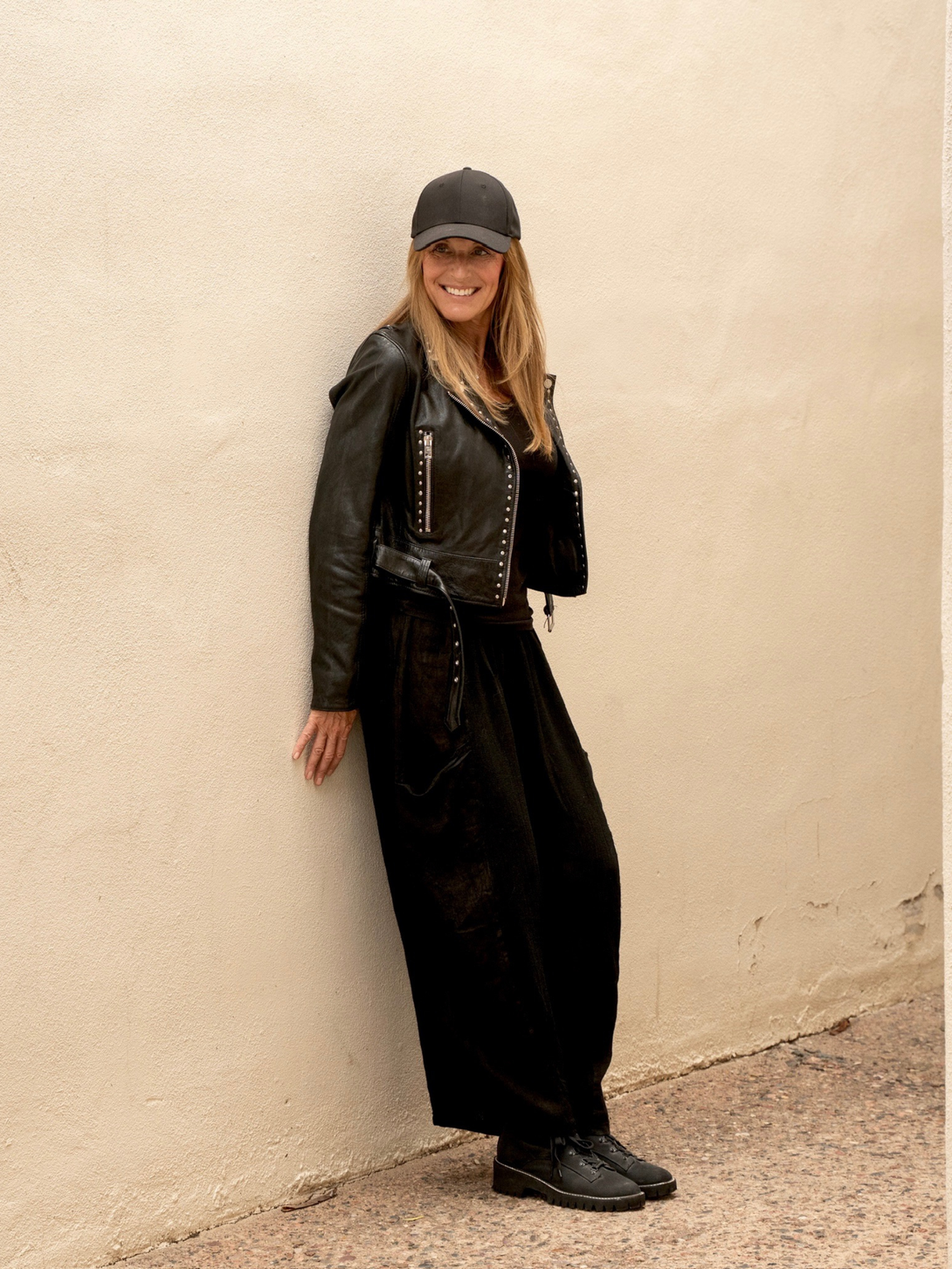 Conscious Coterie Maryn leather jacket in black full body photo of woman wearing jacket showing side view of jacket