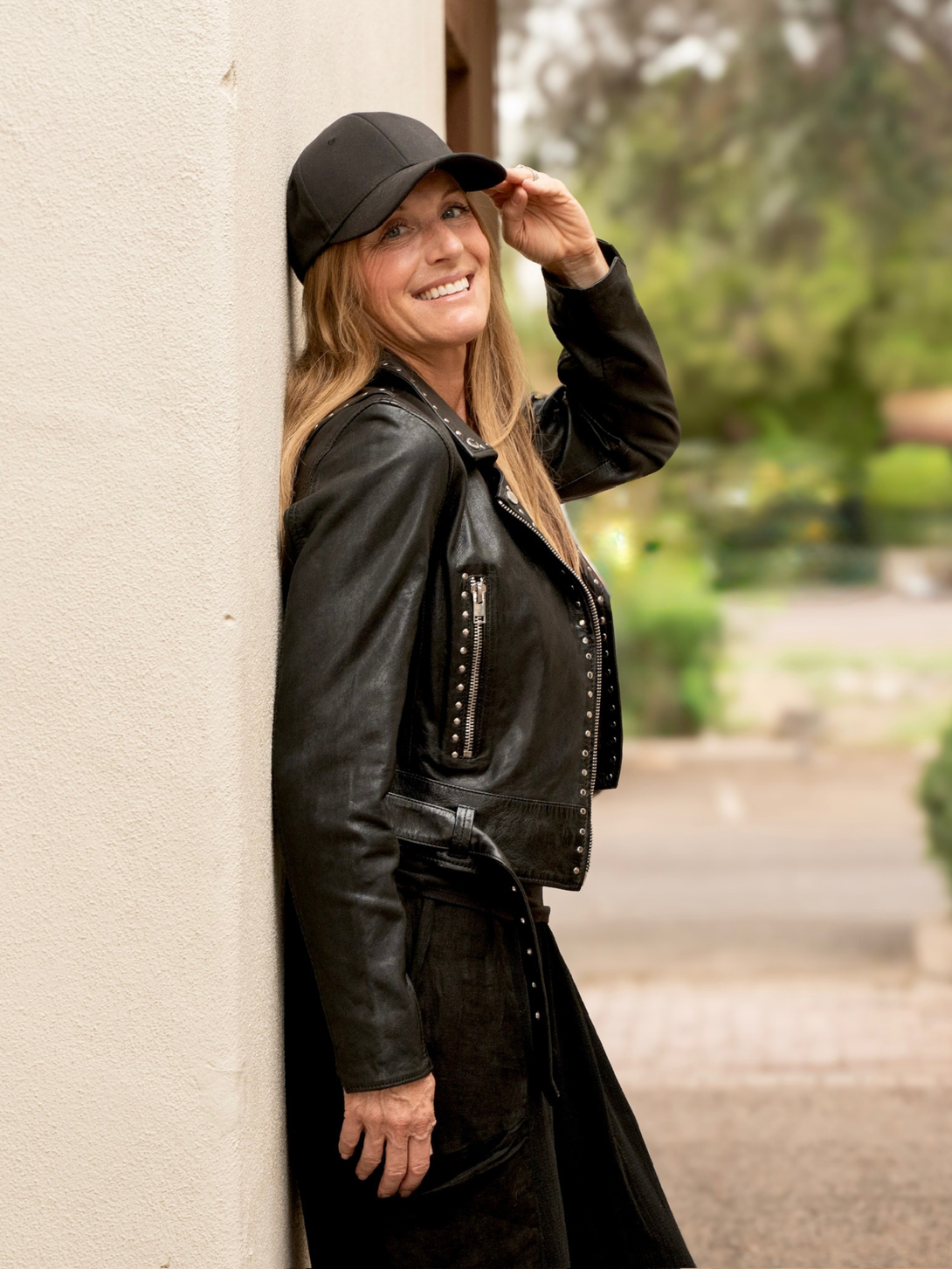 Conscious Coterie Maryn leather jacket in black side view of jacket on woman smiling at the camera