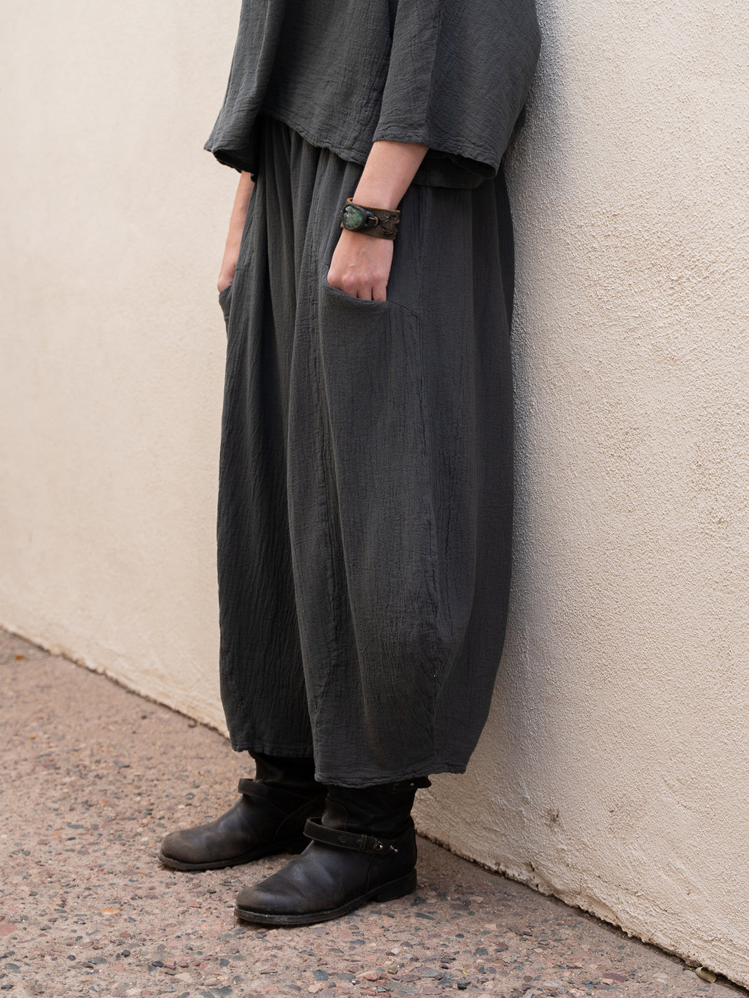Conscious Coterie Mickey Pant in charcoal cotton on model with hands in pockets side bottom view
