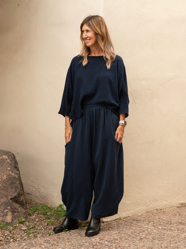 Conscious Coterie Mickey pant in navy blue woman facing forward showing front view of pants with hands in pant pockets