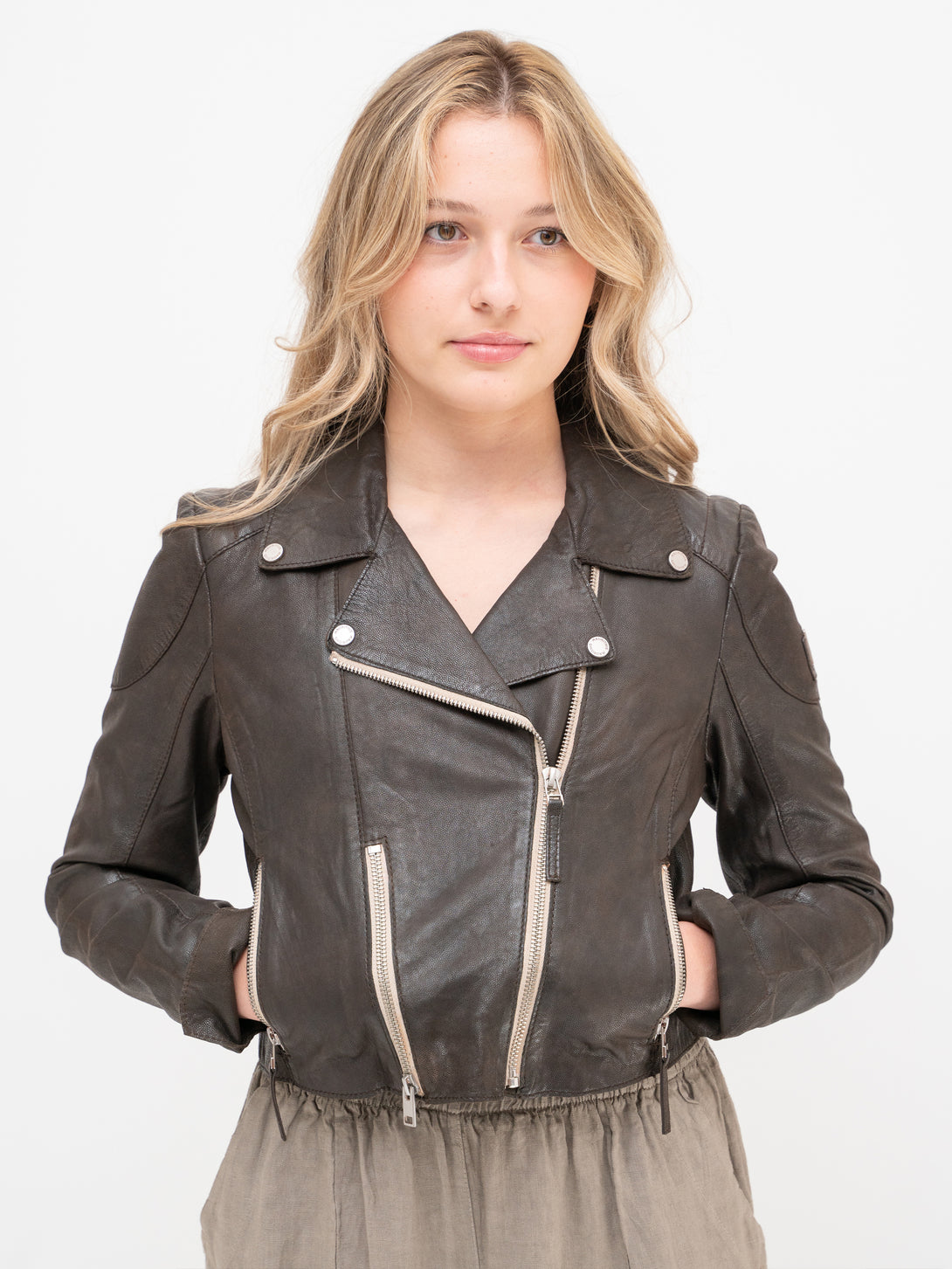 Conscious Coterie Reanon Leather Jacket in brown on model with hands in pockets front view