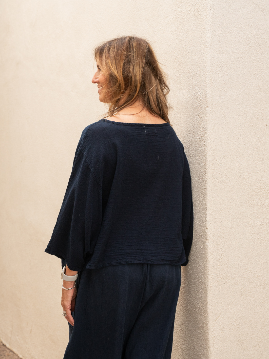 Conscious Coterie Rosie top in navy blue model facing away showing back view of top