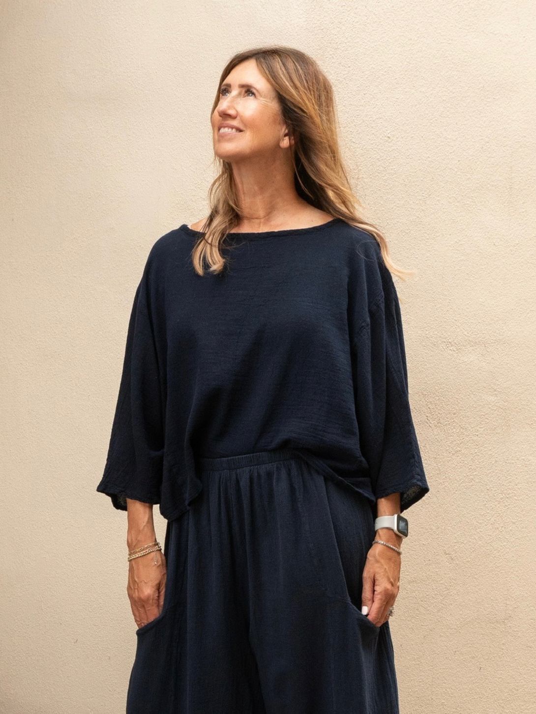 Conscious Coterie Rosie top in navy blue model showing front view of top looking up at the sky