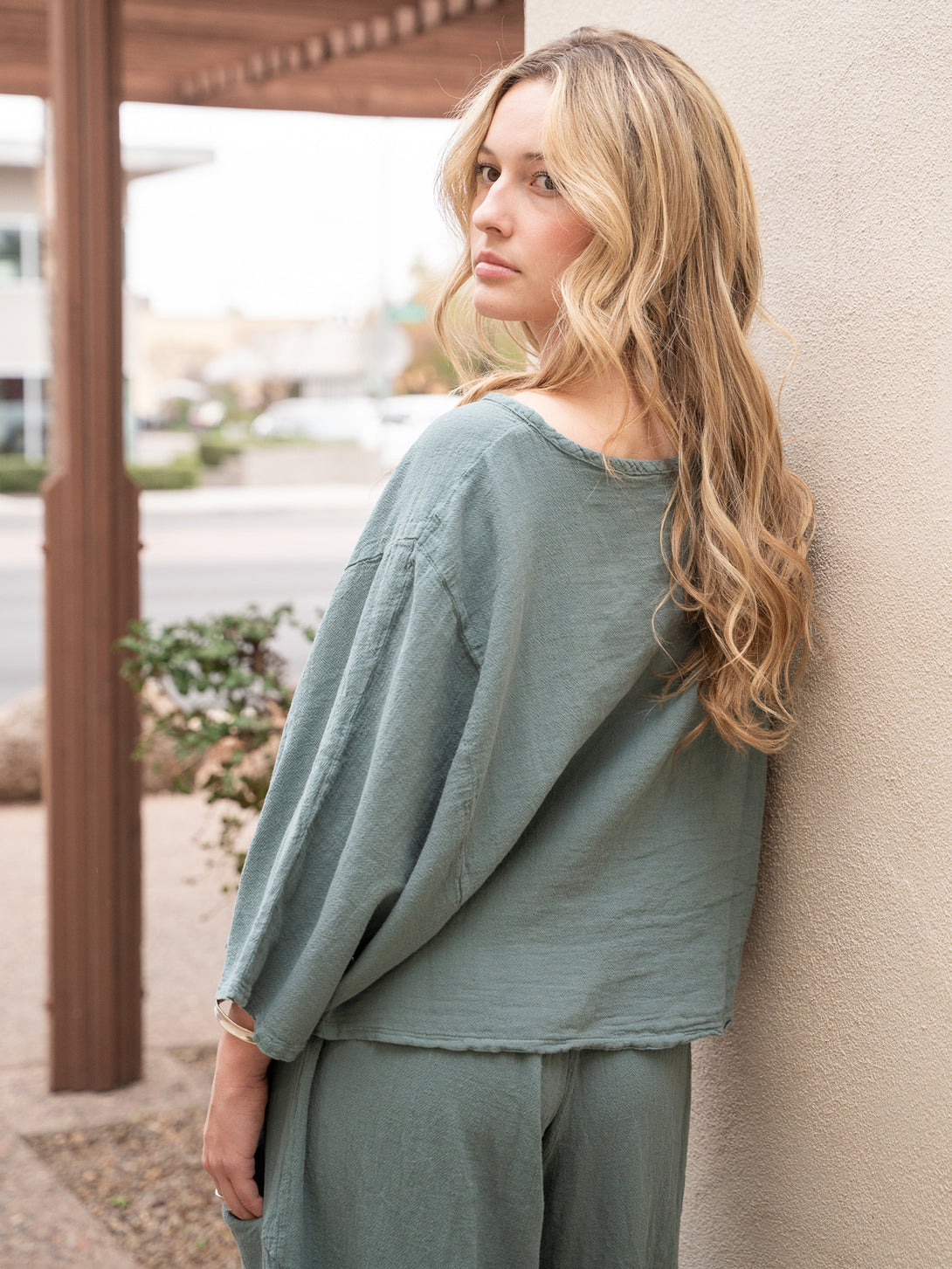 Conscious Coterie Rosie Top in sea cotton on model looking over shoulder back view