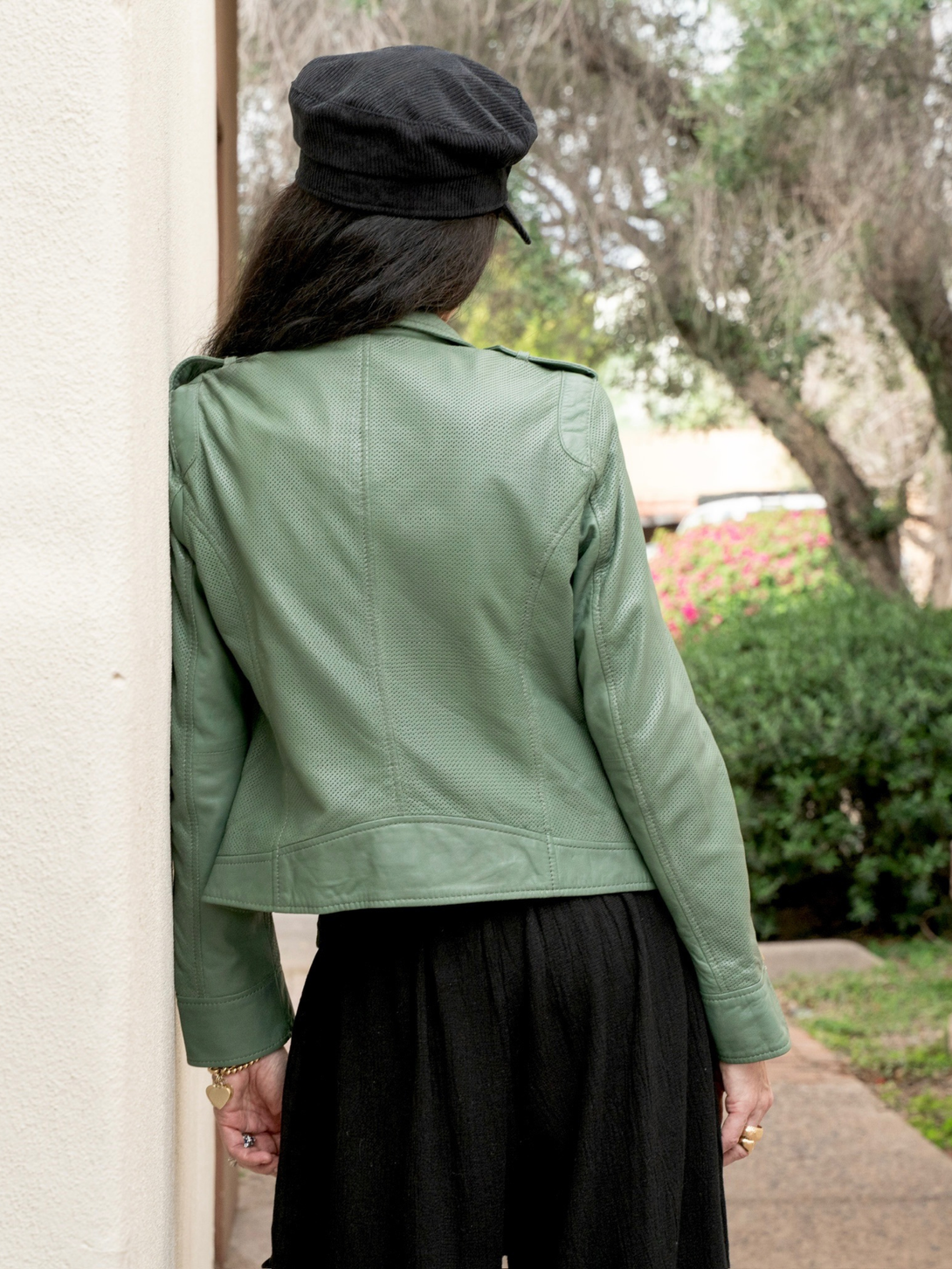 Conscious Coterie Sinta leather jacket in sage green photo of woman facing away showing the back of the jacket