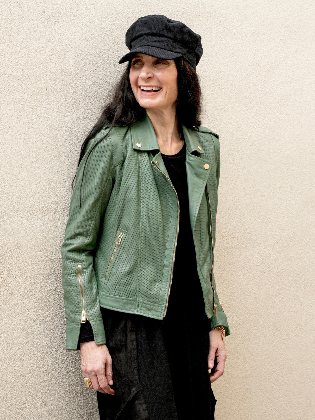 Conscious Coterie Sinta leather jacket in sage green close up photo of the front and side of the jacket on a woman