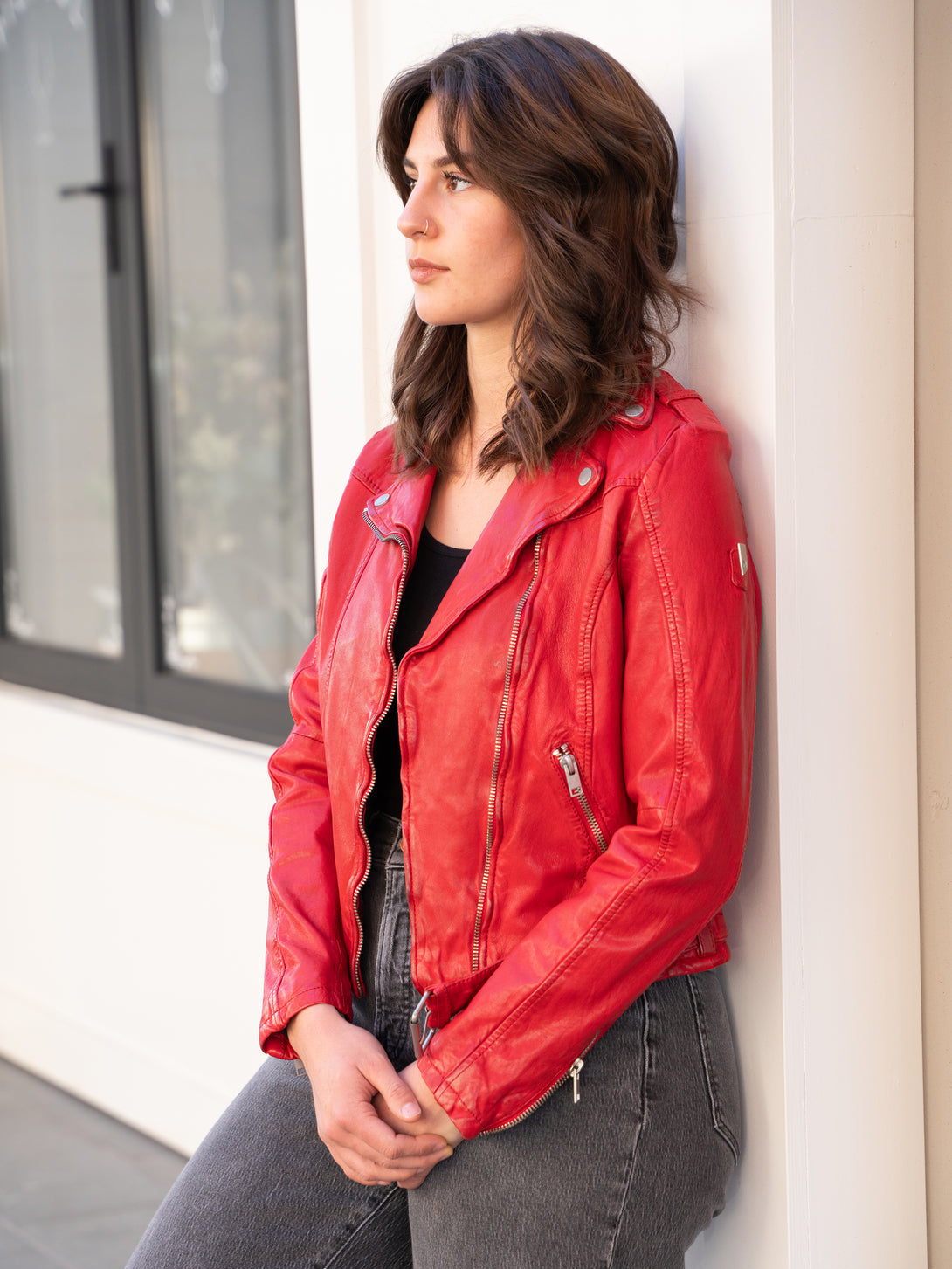 Conscious Coterie Wild Leather Jacket in red on model leaning against wall front view