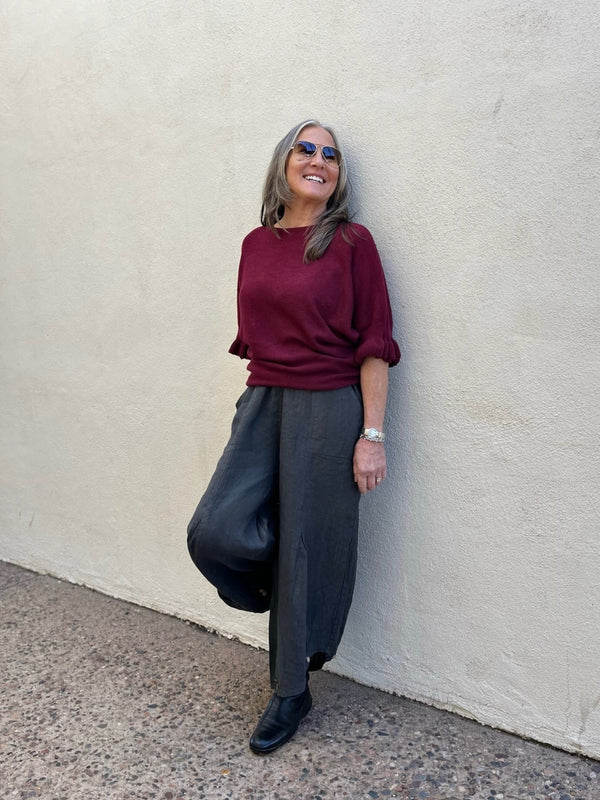 Conscious Coterie Yoli Pant in Charcoal full body view of pants on woman with one leg on the wall