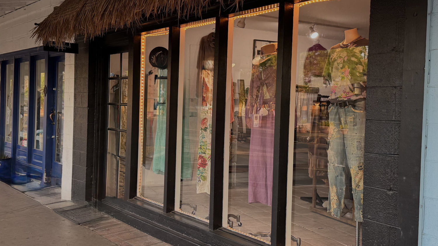 Row of shops with glass windows displaying traditional clothing.